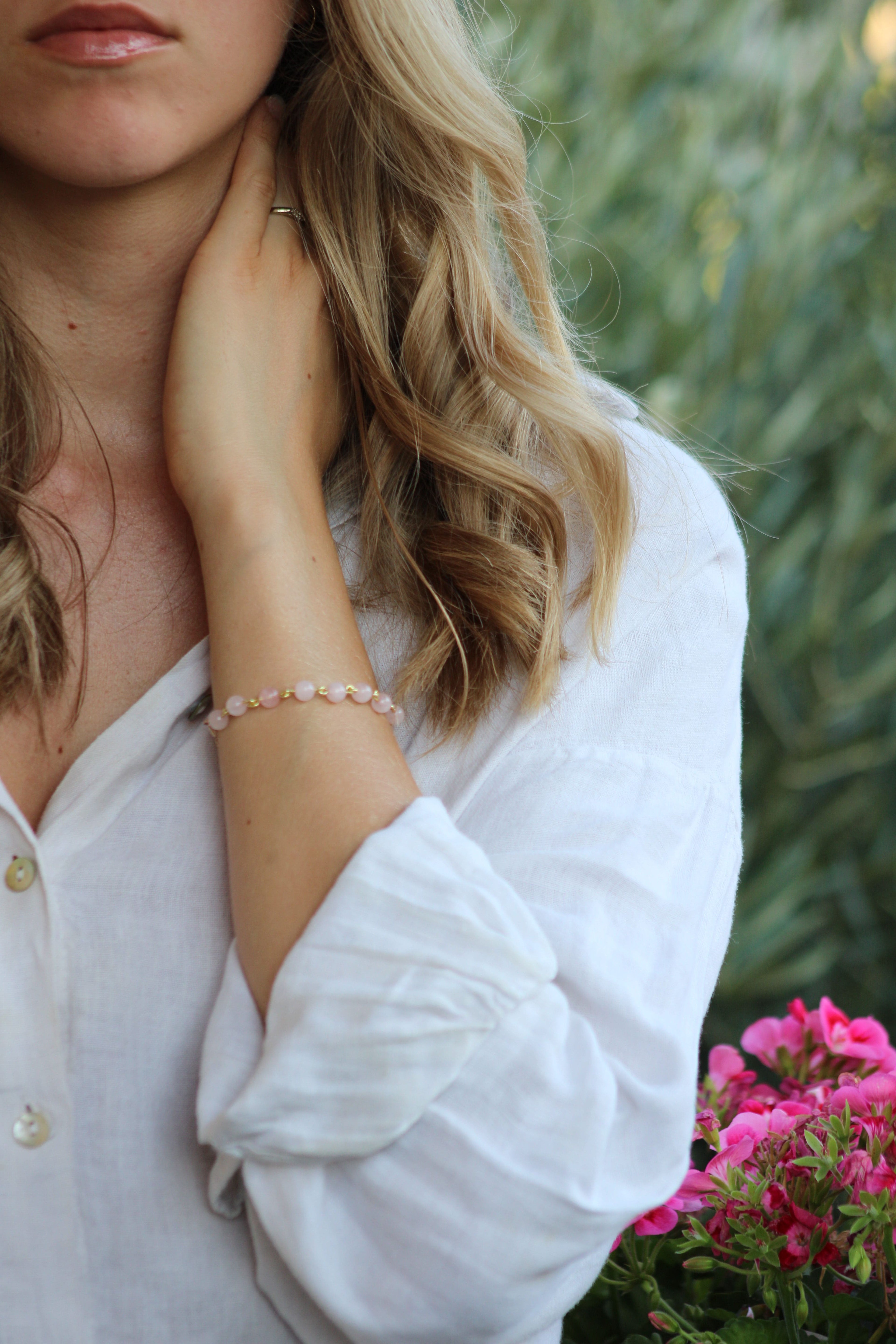 photo d'une femme portant le bracelet Ornéa en perles naturelles de quartz rose, finition or